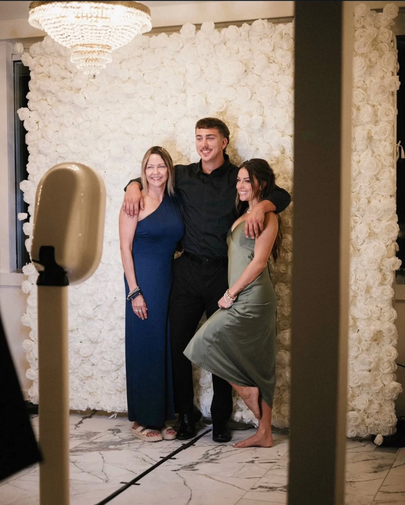 Family posing for a photo at the Modern Booth during a wedding reception, creating keepsakes with a modern digital photo booth experience