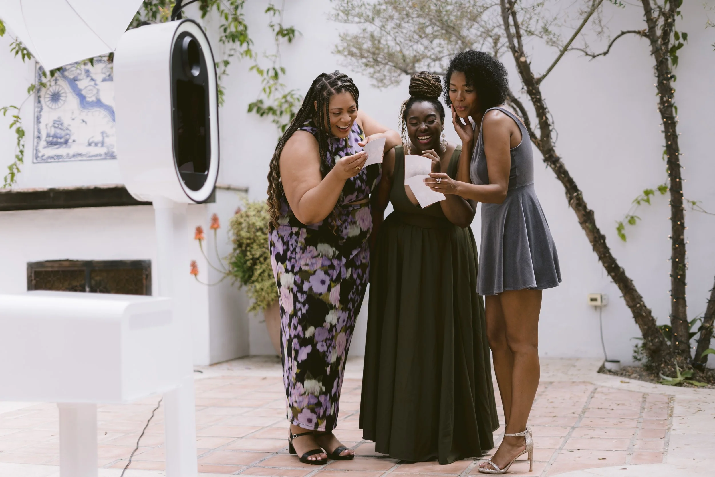 Guests viewing and sharing their photo booth pictures during an outdoor event in Savannah