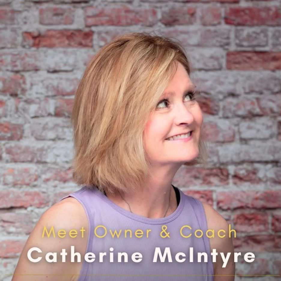 Photo of Catherine McIntyre, a woman with blonde hair wearing a purple sleeveless top, smiling and looking up against a brick wall background. Text overlay reads "Meet Owner & Coach Catherine McIntyre."