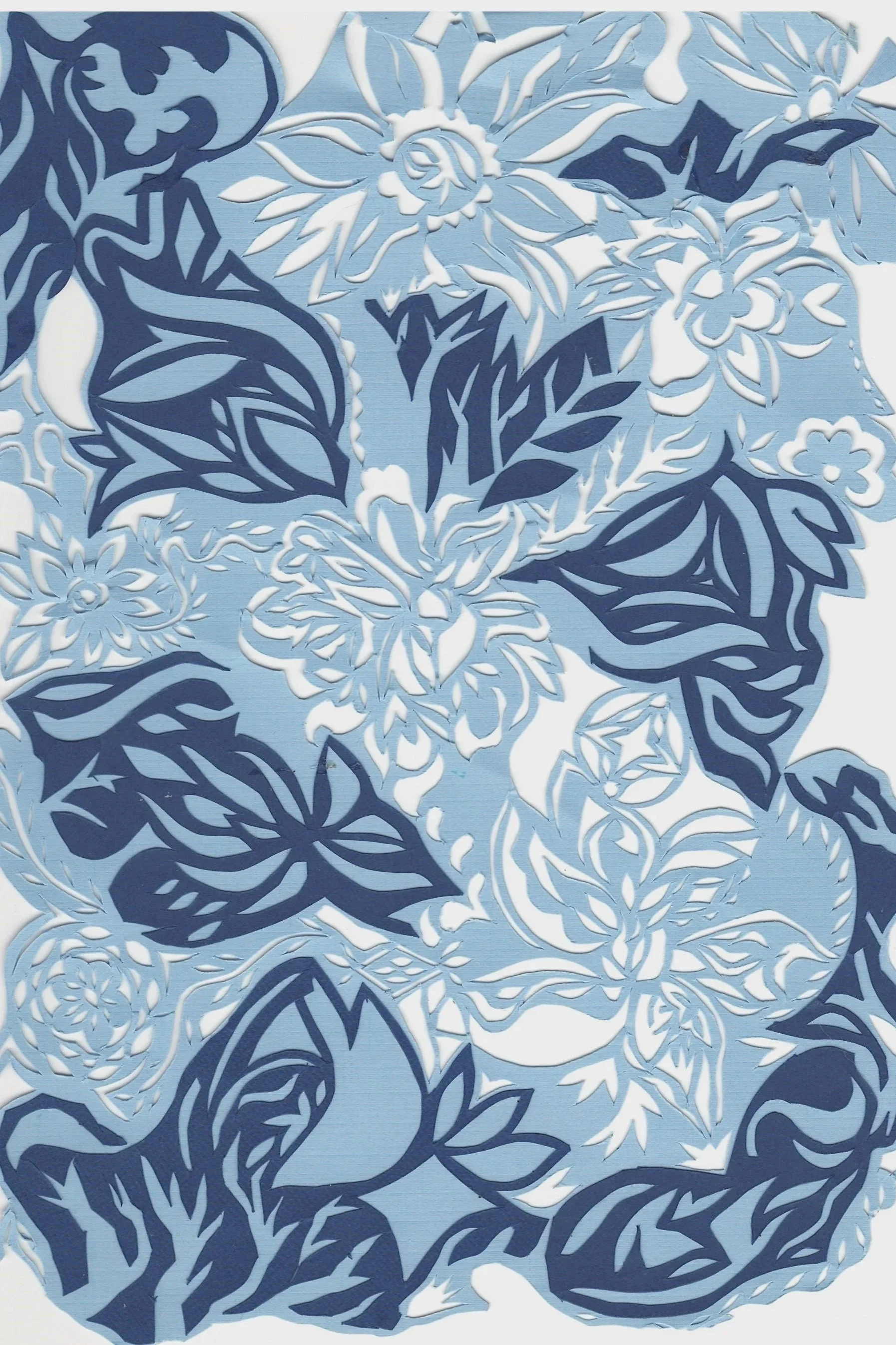 Detailed paper cutout of floral and leaf patterns in dark blue and white on a light blue background.