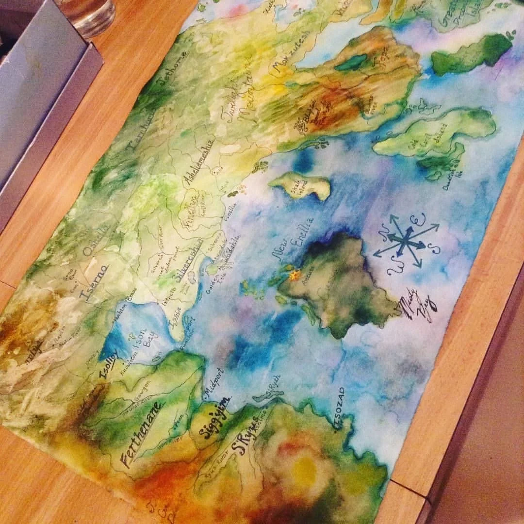 Hand-painted map of a science fiction novel showing regional names and geographical features, with a compass rose in the sea area.