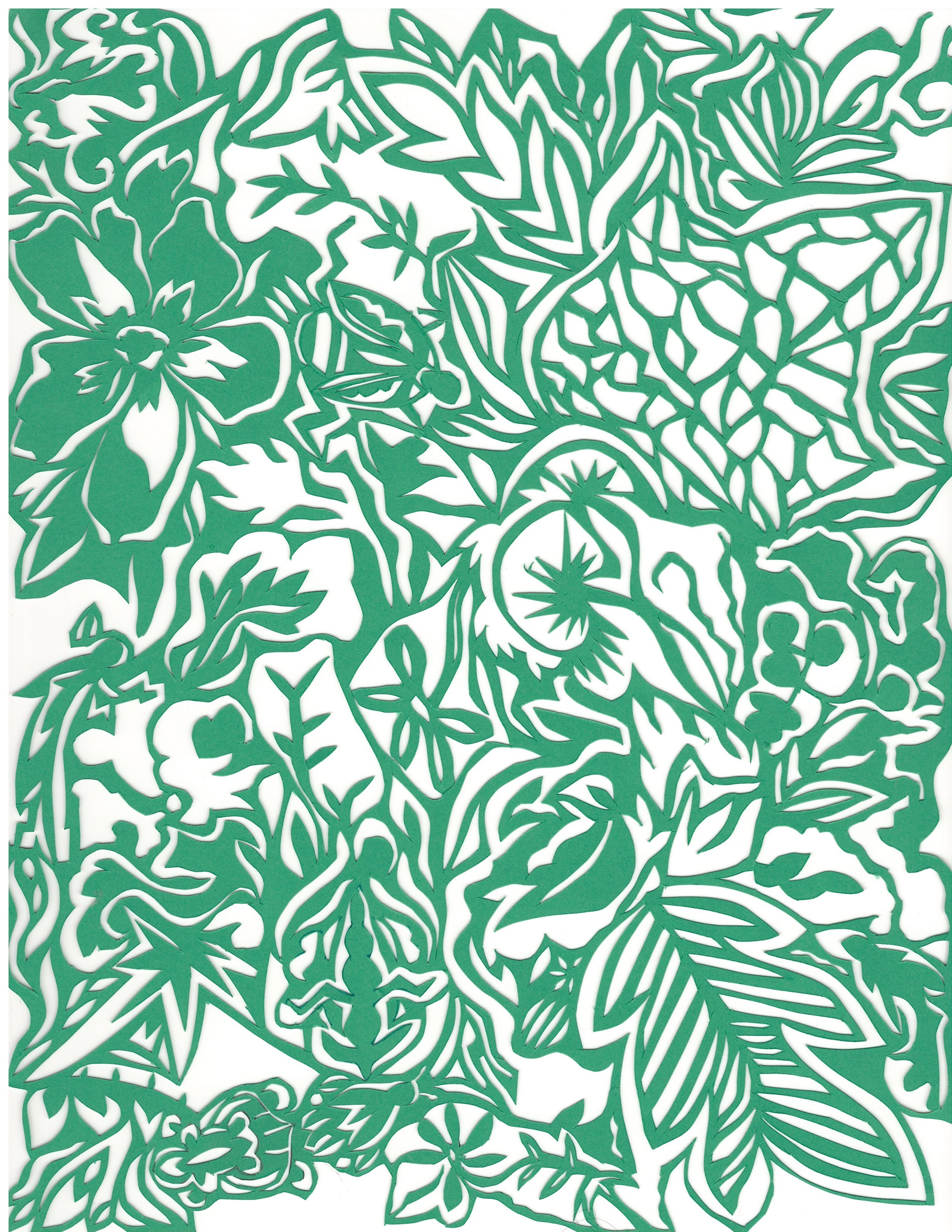 Green and white intricate floral and foliage paper cutout design.