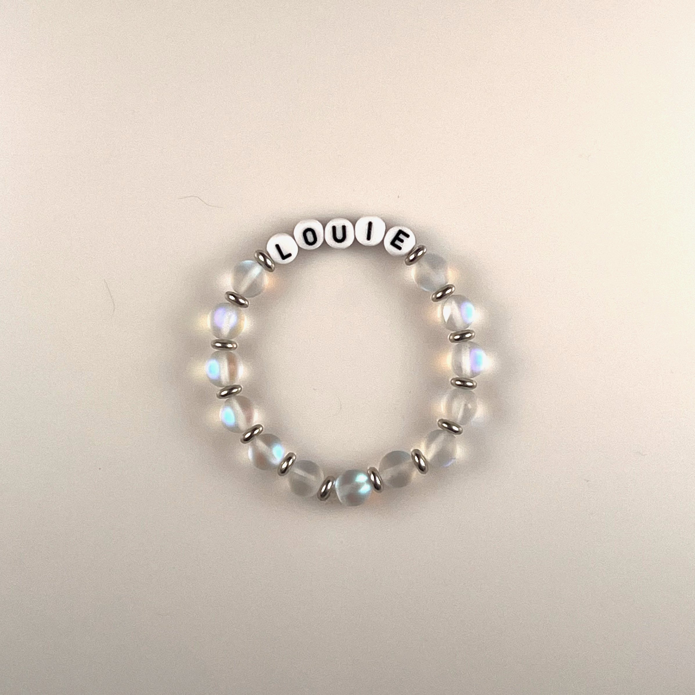 Louie: A customizable bracelet made with frosted clear beads, silver spacers and black letters on white beads. Personalize with a name or your favorite word. Up to 10 letters. $25