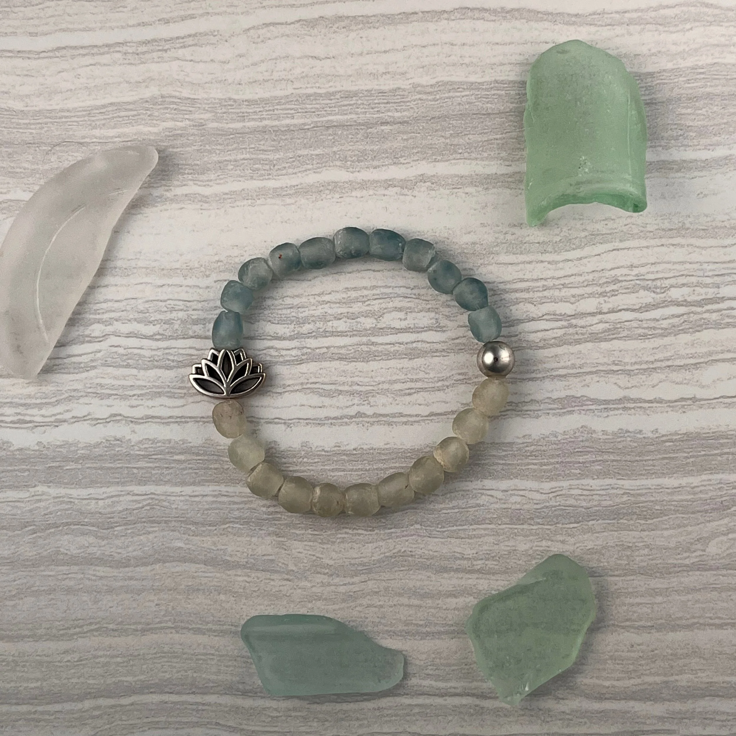 Ocean Lotus: Ocean Lotus combines recycled blue and clear glass beads with a silver accent bead and delicate lotus charm. $20