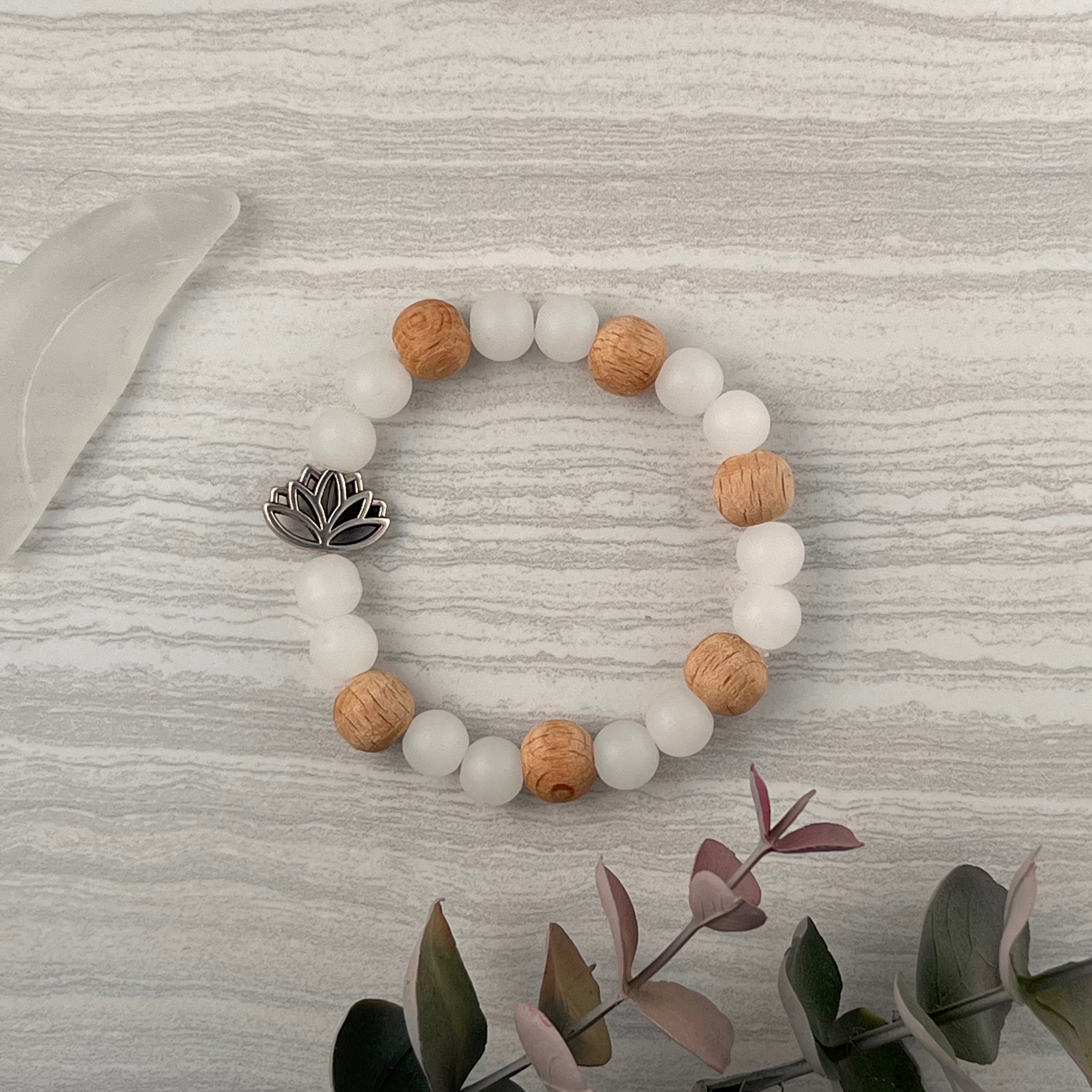 Driftwood Lotus: Frosted white glass beads paired with warm wood accents and a silver lotus charm. Perfect for relaxing by the water or adding a touch of the coast to your every day style. 
$20 