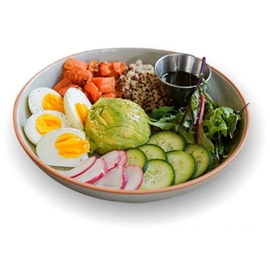A bowl of salad with sliced cucumbers, radishes, avocado, boiled eggs, diced salmon, quinoa, and leafy greens, served with a small cup of dressing.
