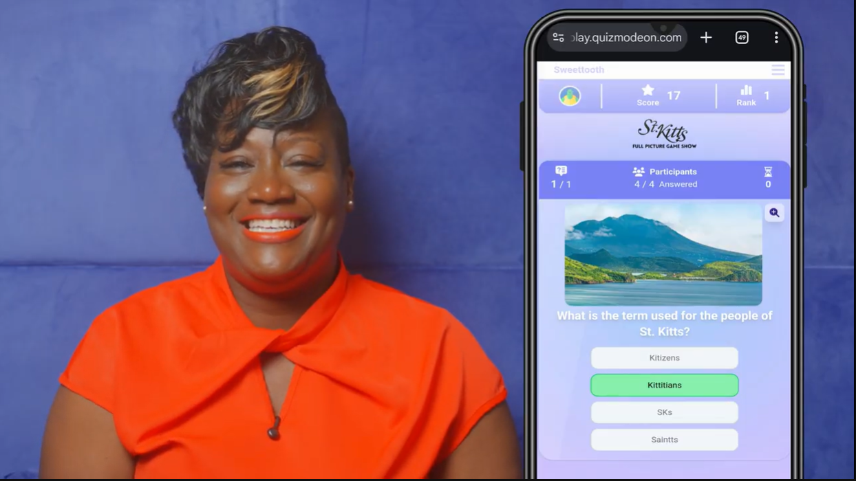 Woman smiling in an orange top next to a smartphone screen displaying a quiz question about the people of St. Kitts.