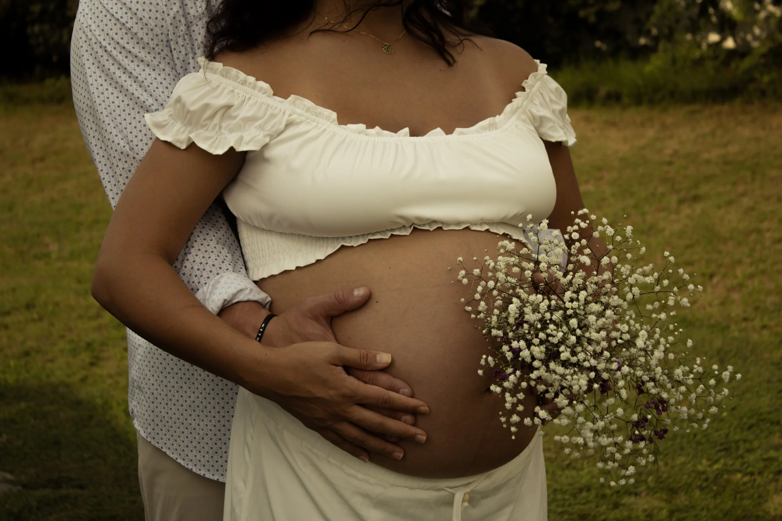 Pregnant couple embracing during an outdoor maternity session in Raleigh, NC.