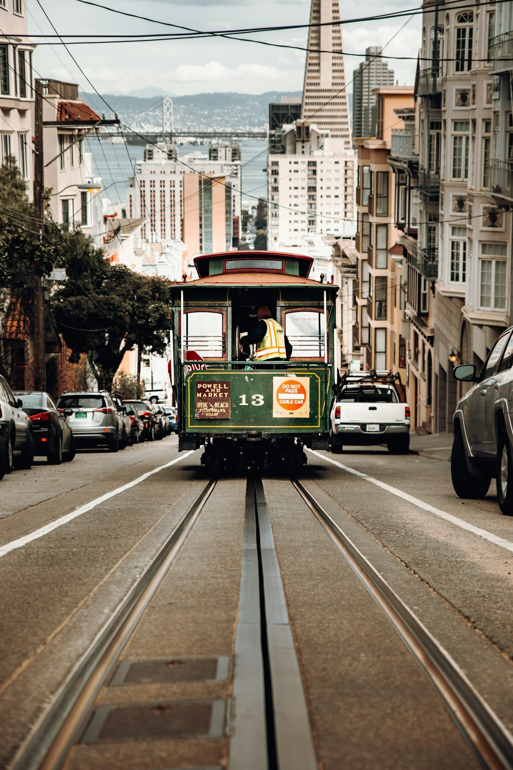 San Francisco cable car traveling uphill along a residential street lined with historic buildings.