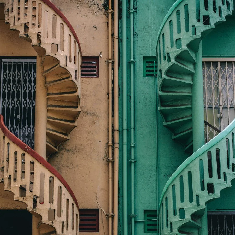 Two mirrored spiral staircases, one cream and one green