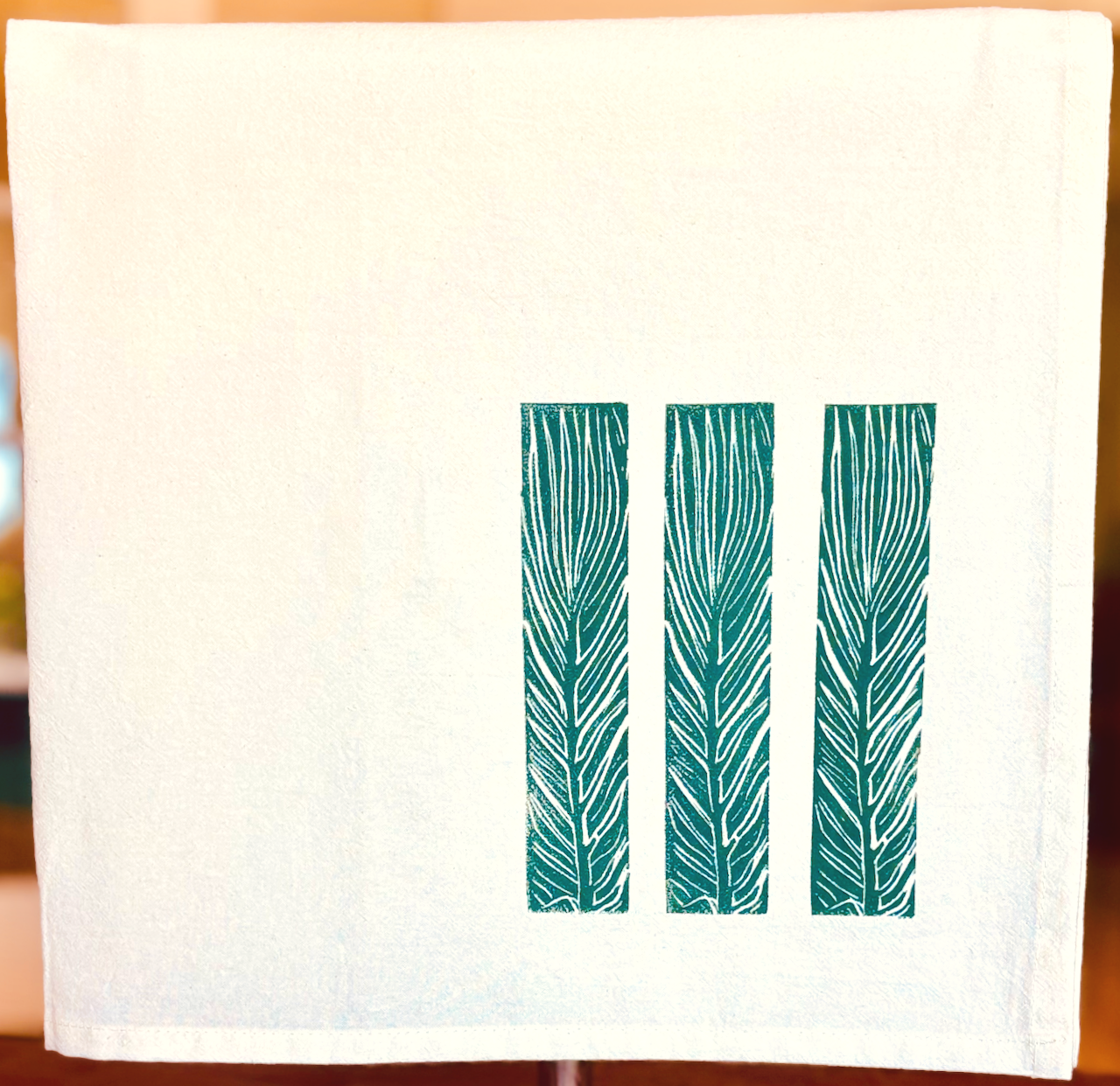 Image of cotton tea towel with original Canna 'Tropicana' leaf linocut design from Handforth Botanical Studio