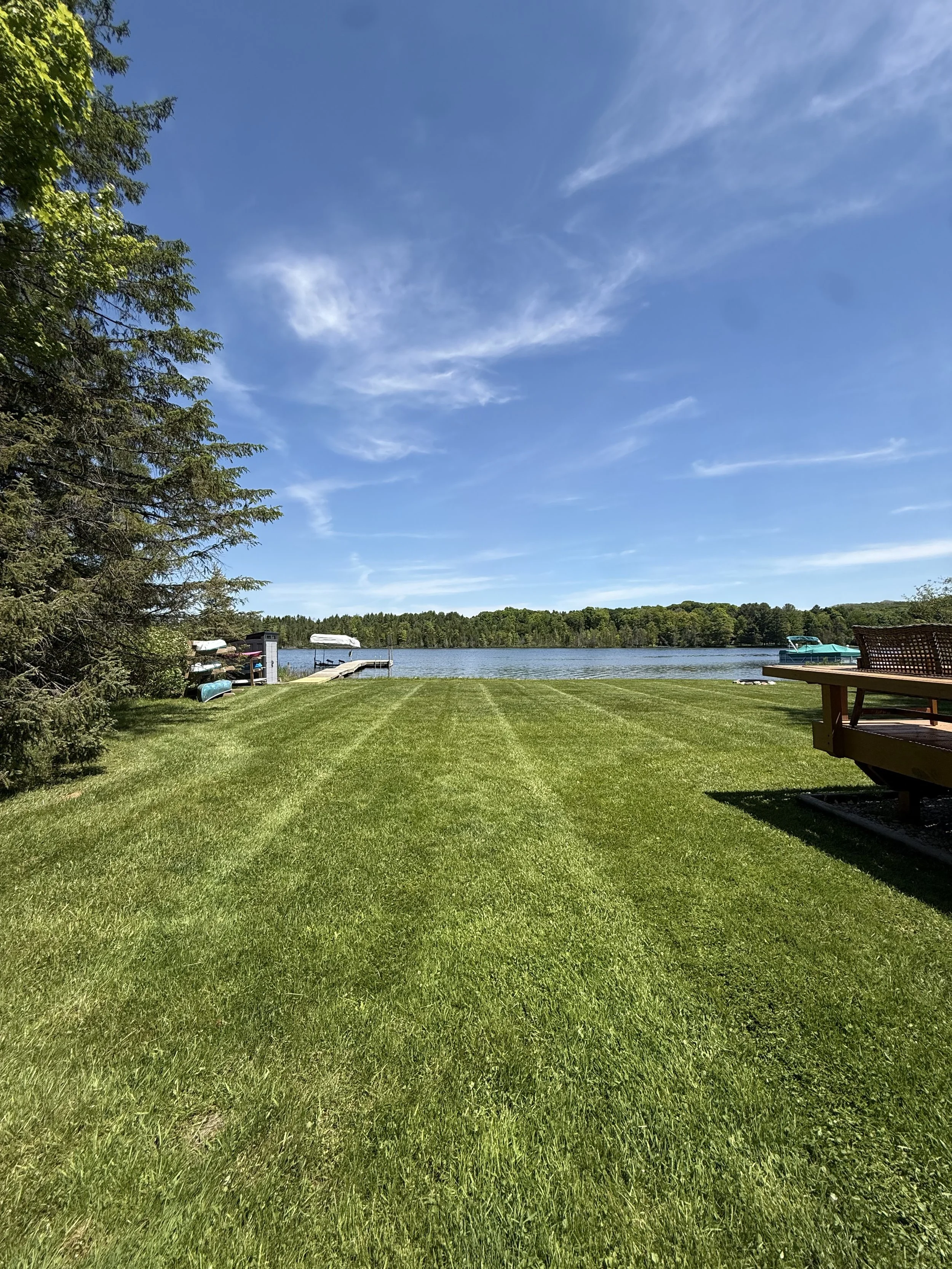 Freshly striped waterfront lawn leading to a dock on Clam Lake