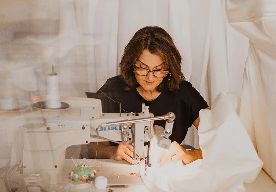Connie sewing a wedding dress with a sewing machine in the alterations workspace upstairs in Accapella Bridal, Wollongong NSW