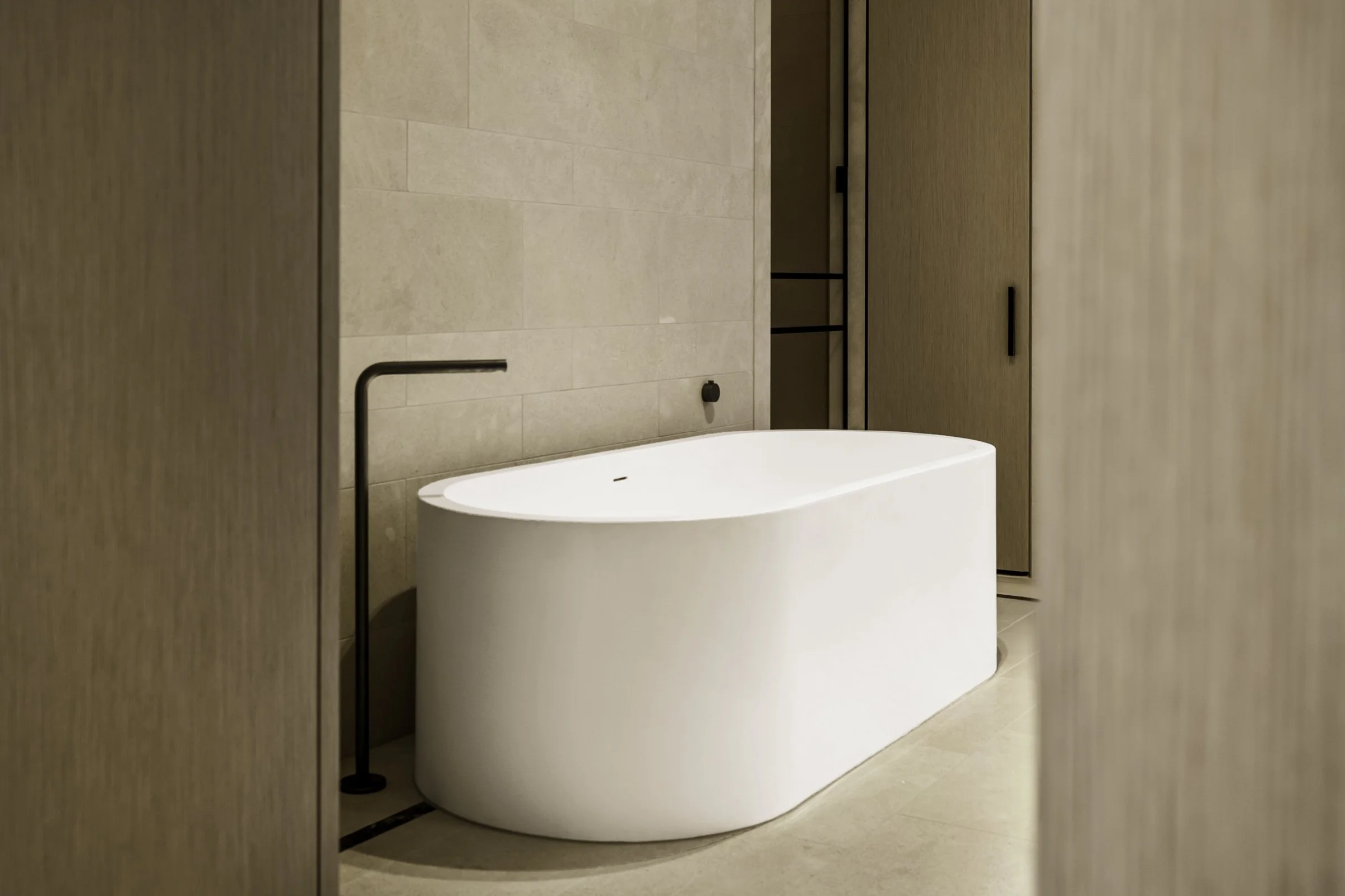 Modern bathroom with a freestanding bathtub, beige tiled walls, and wooden cabinetry.