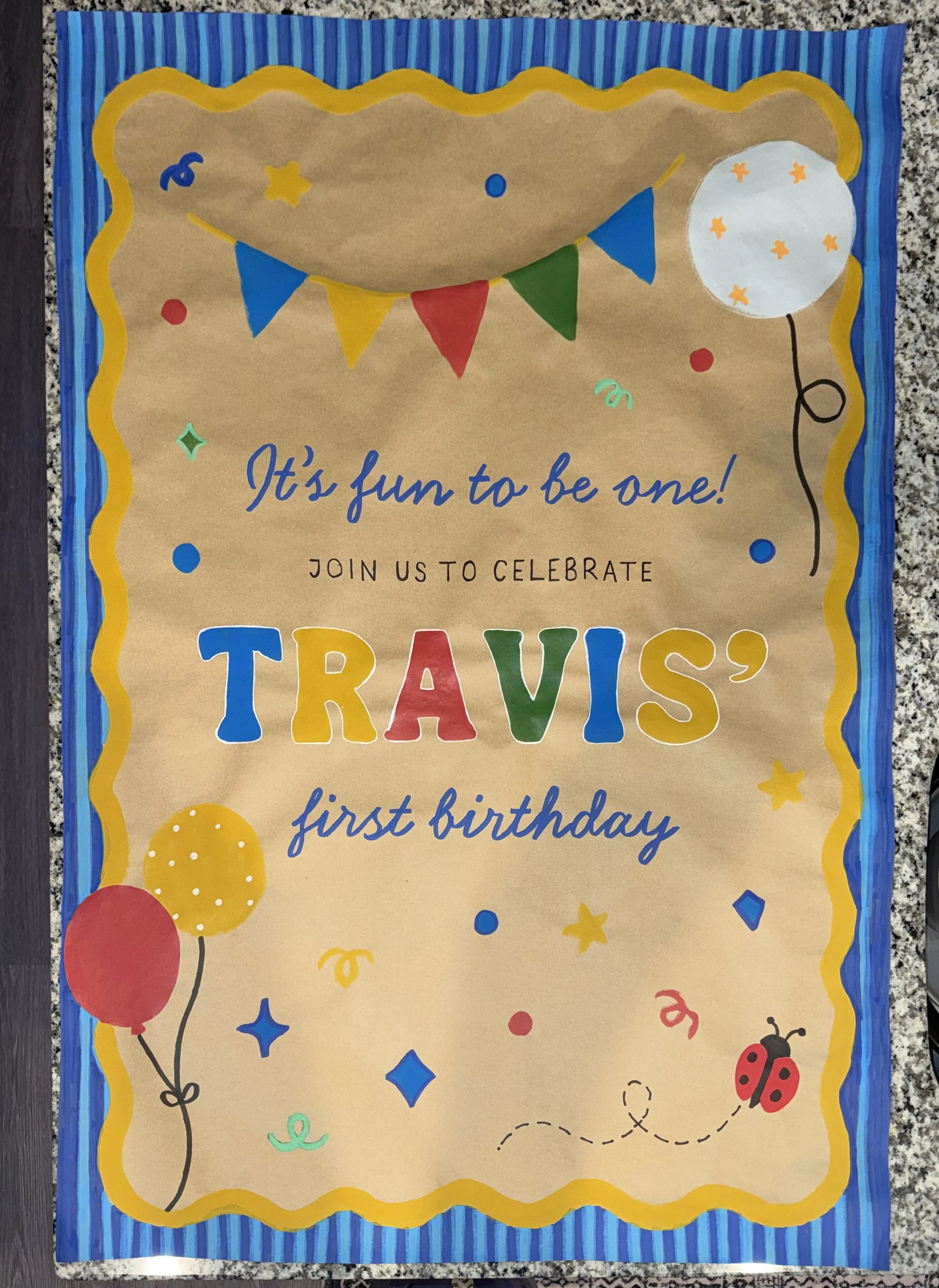 Colorful birthday invitation featuring balloons, confetti, ladybug, and a moon, with the message 'It's fun to be one! Join us to celebrate Travis' first birthday'.