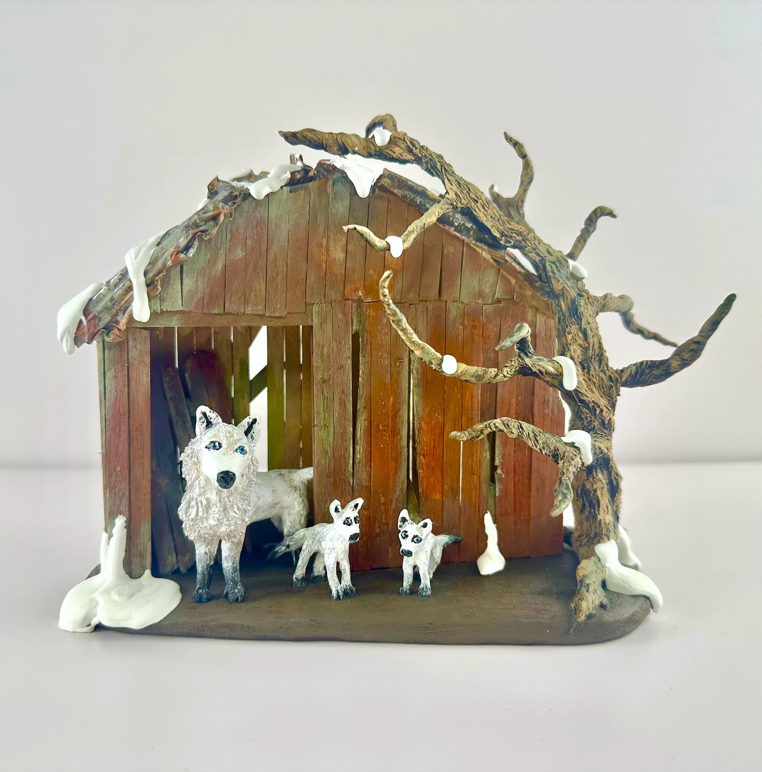 White Winter Wolves Figurines in a Red Shed and a Winter Tree