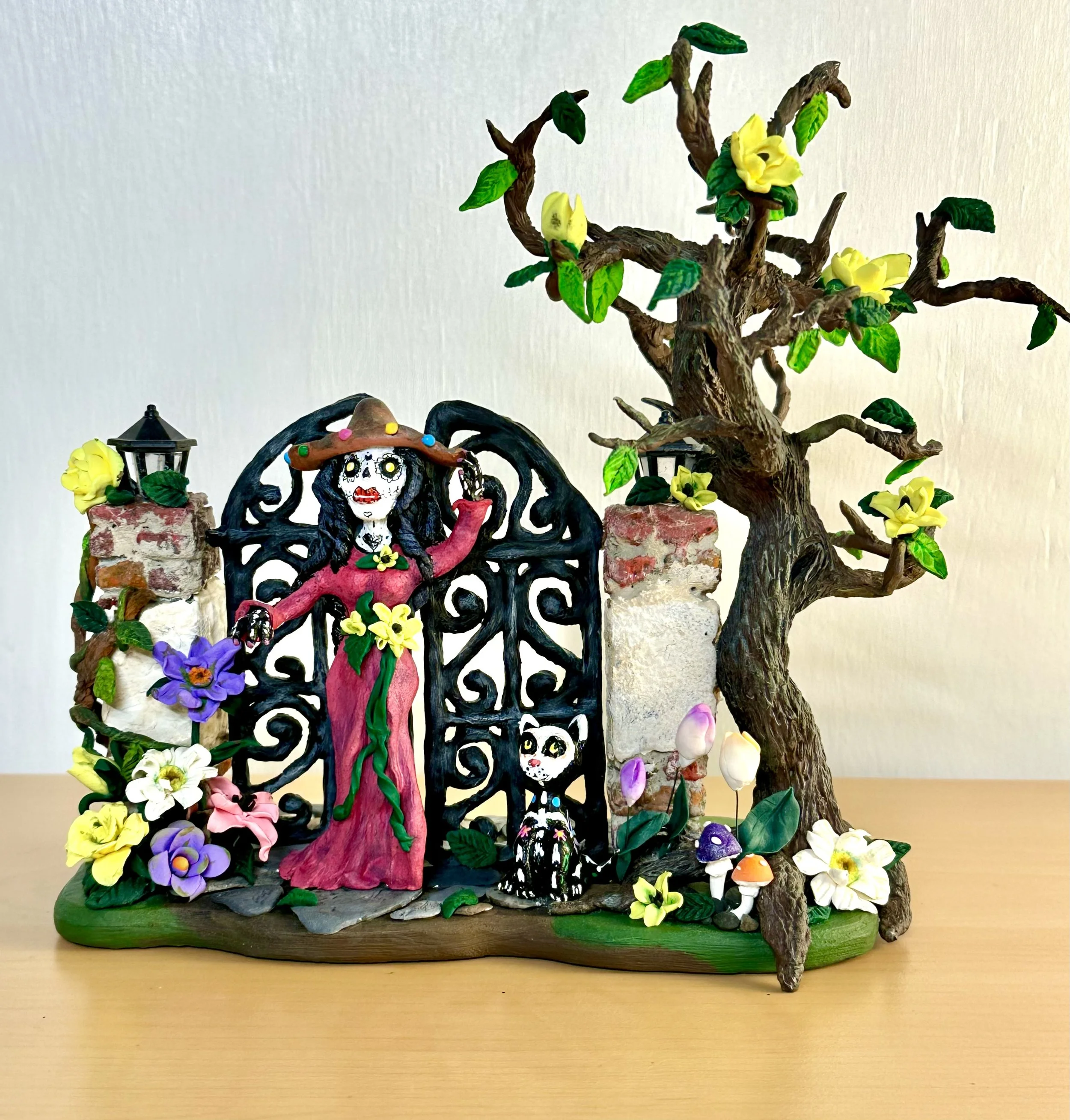 Black Haired Woman Figurine in front of a Day of the Dead Gate