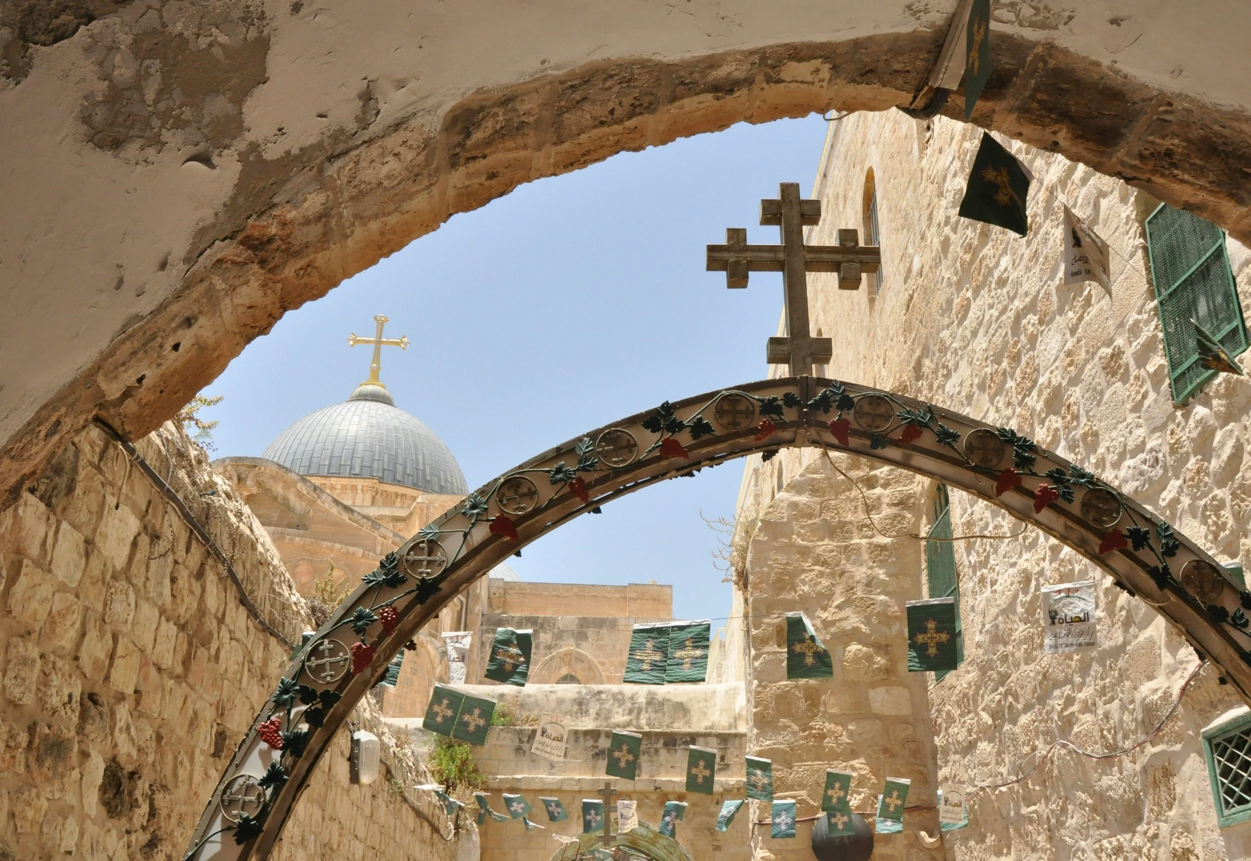 Historic stone alleyway in Jerusalem's Old City decorated with Christian crosses, a destination on Holyland Horizons pilgrimage journeys to the Holy Land