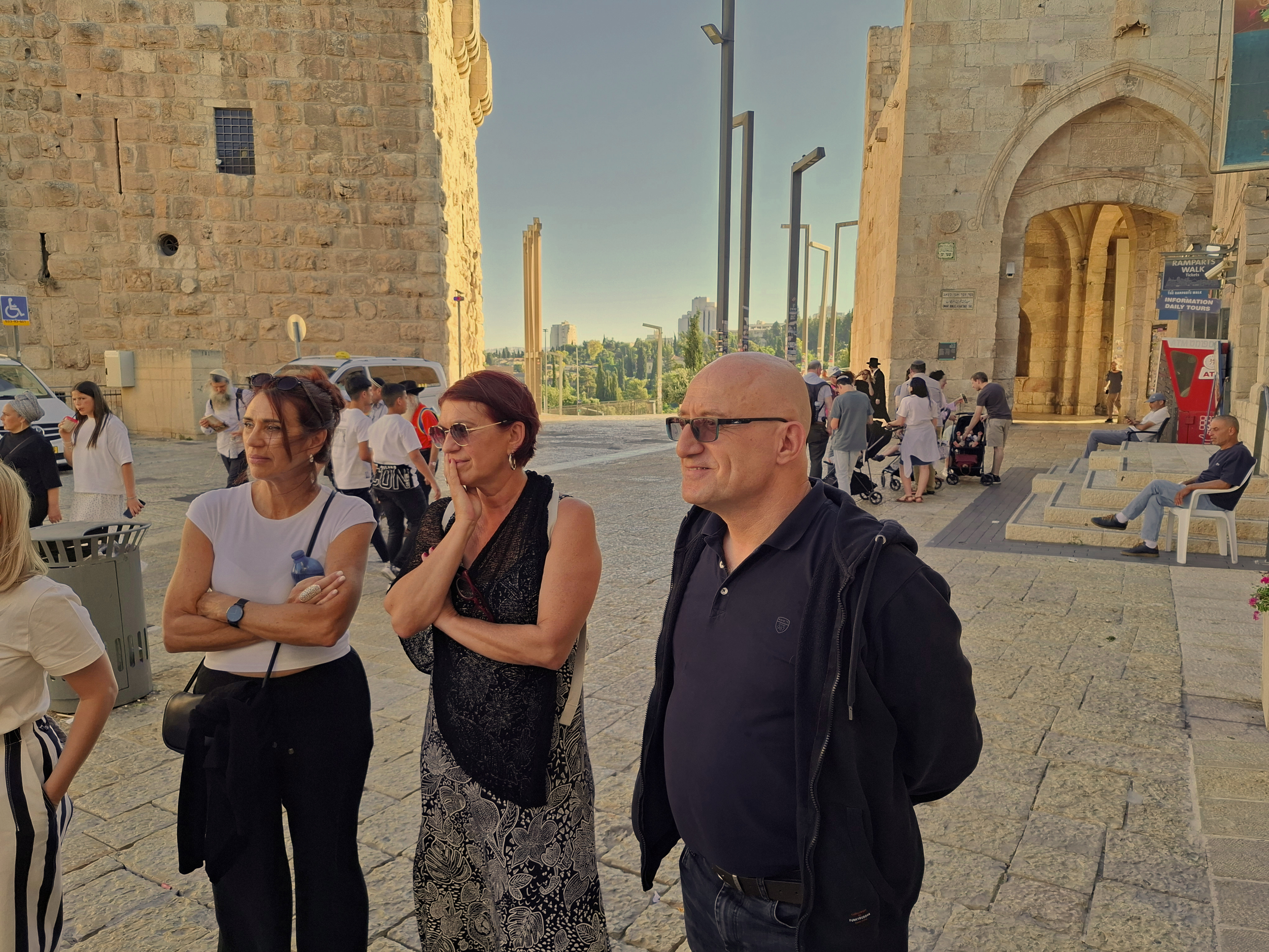 Visitors walking and sitting under historic stone archways in Jerusalem's Old City at night during the Holyland Horizons After Dark walking tour