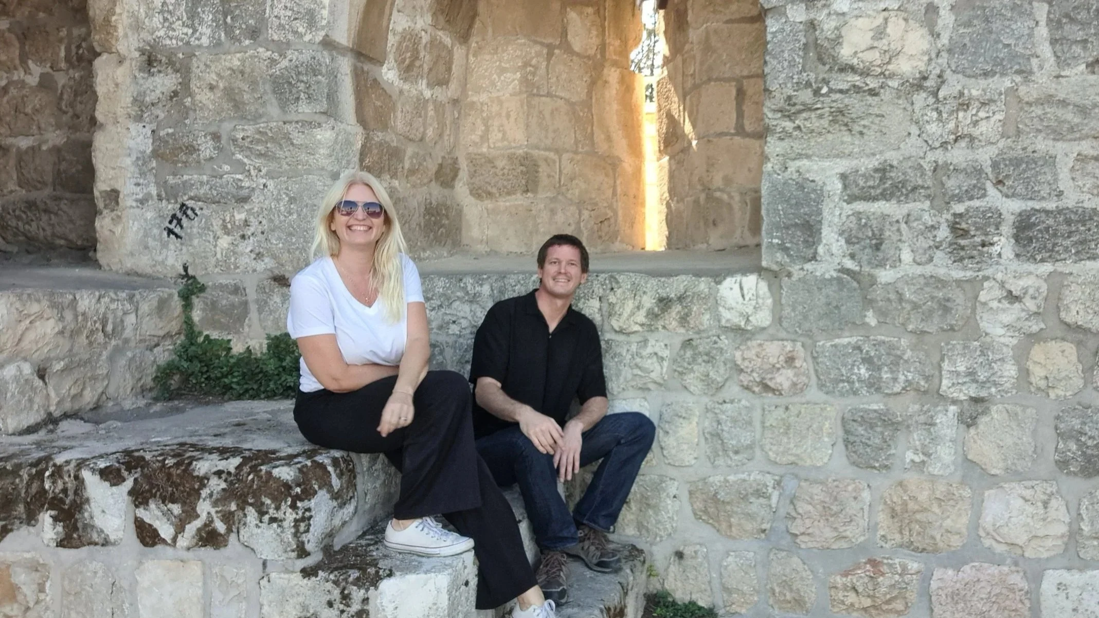 Toon Van Rompay and Alena Levy, co-founders of Holyland Horizons, smiling together on ancient stone steps in Israel
