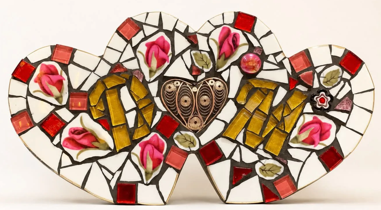 Mosaic heart-shaped art piece with pink flowers, red, pink, and clear glass tiles, and intricate metalwork at the center.