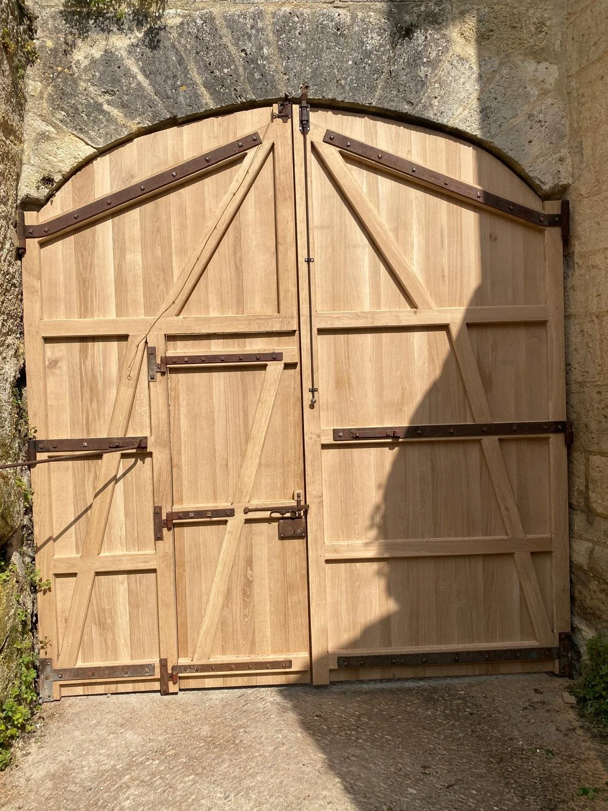 Porte en bois avec ferrure, avec porte intégrée, accès aux catacombes Saint-Emilion.