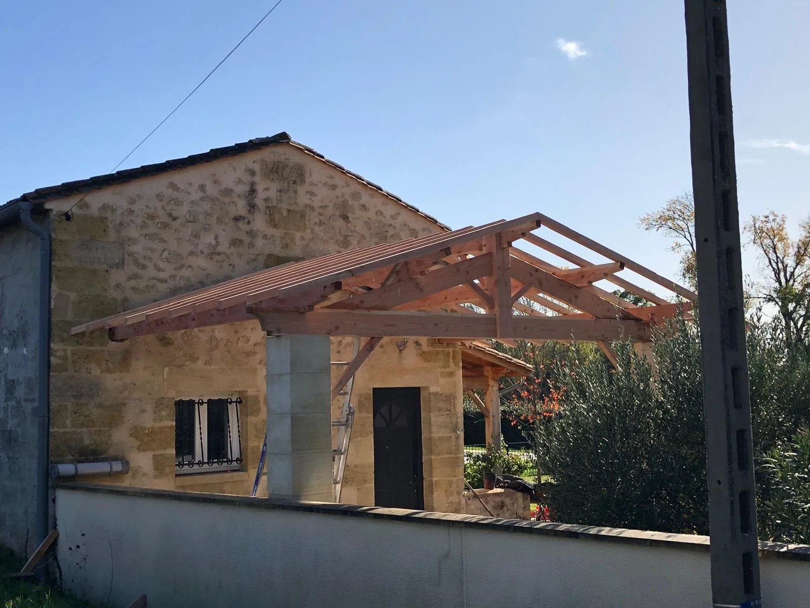 Construction d'une extension en bois d'une maison en pierre avec un toit en construction.