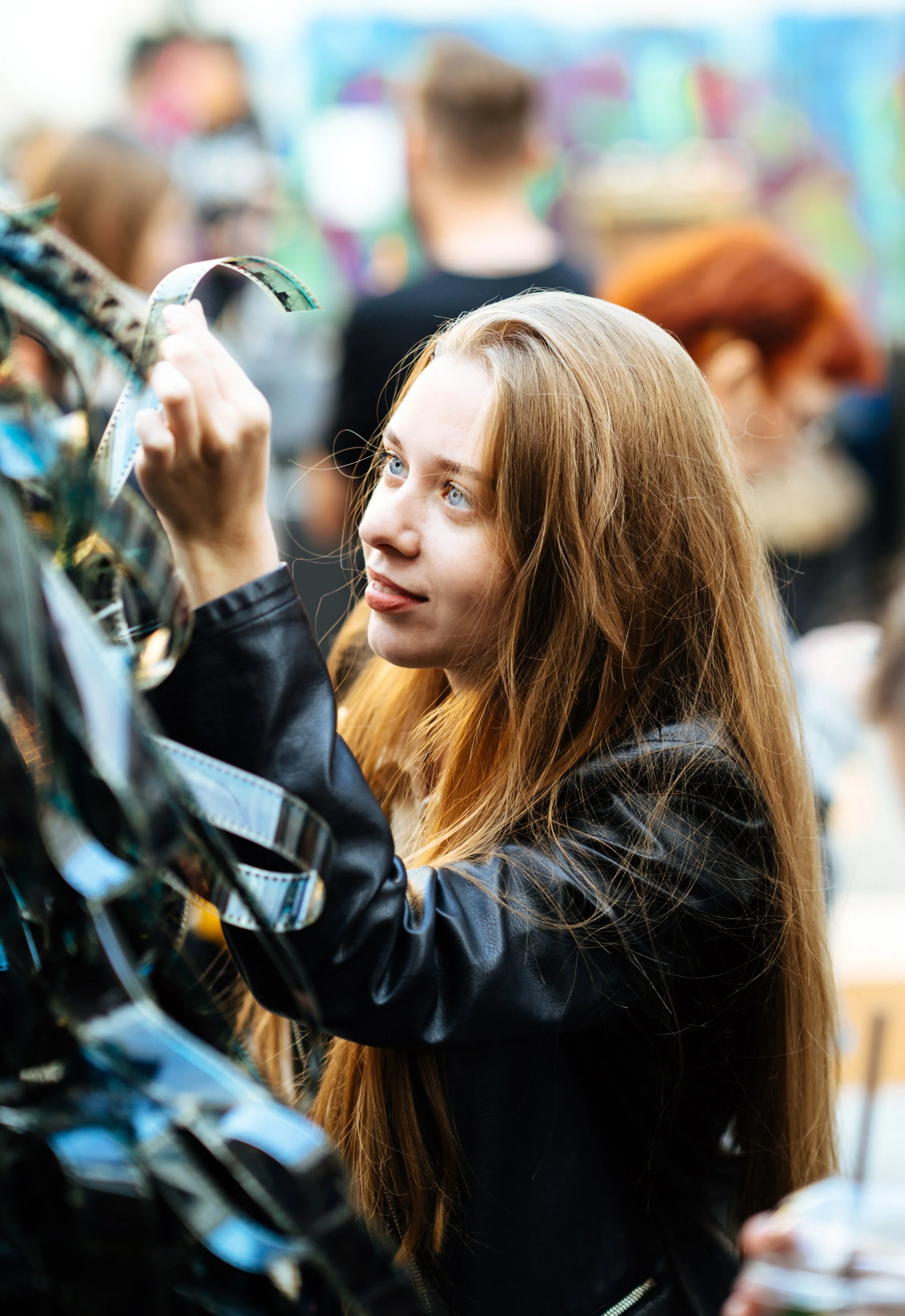 A young woman with red hair and blue eyes examining a vinyl record at a record store.