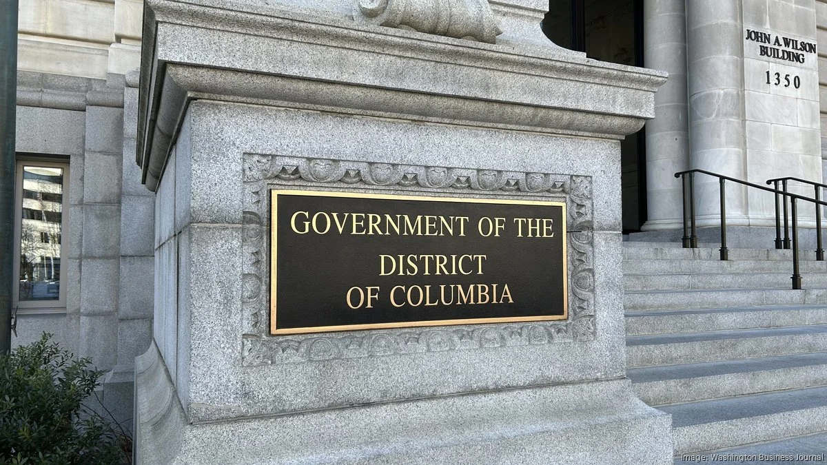 Sign on a stone building that reads "Government of the District of Columbia" with steps leading to an entrance.