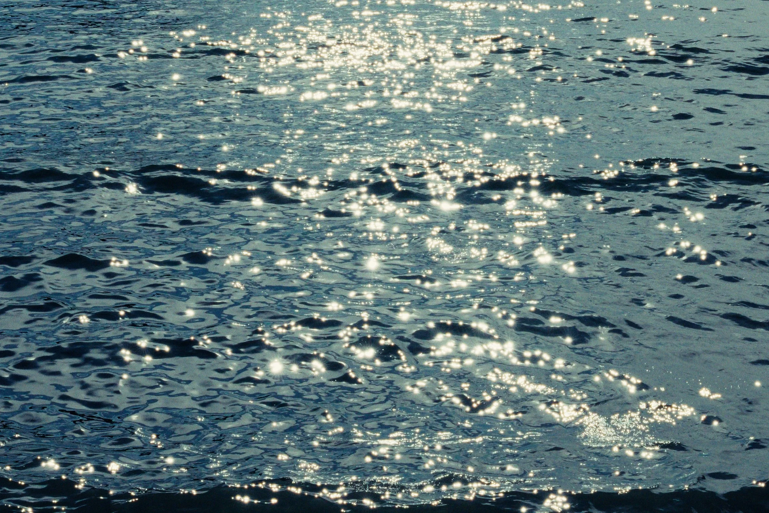 Filmic photo of the sea, water with sunlight reflecting