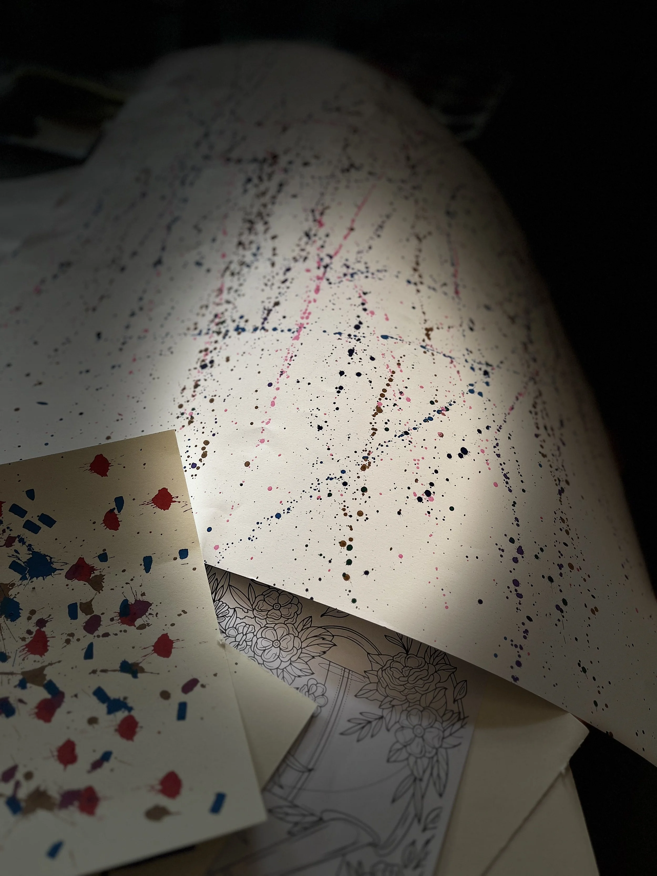 Différentes feuilles de papier avec des motifs de dripping et des motifs géométriques.