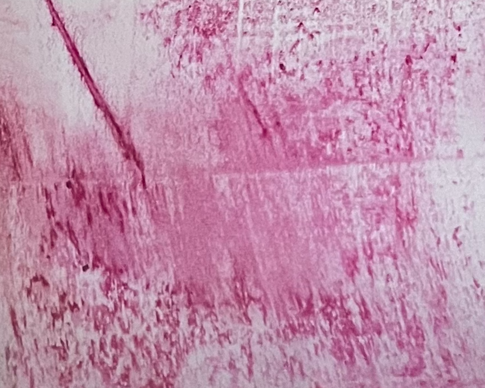 Une photo de pigments roses au pastel gras sur papier calque, avec des traces visibles de frottements et d'empreintes.