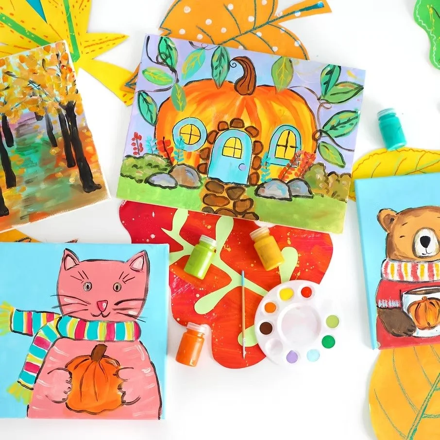 Colorful autumn-themed paintings of a pumpkin house, a pink cat holding a pumpkin, and a bear with a pumpkin, surrounded by leaves and art supplies.