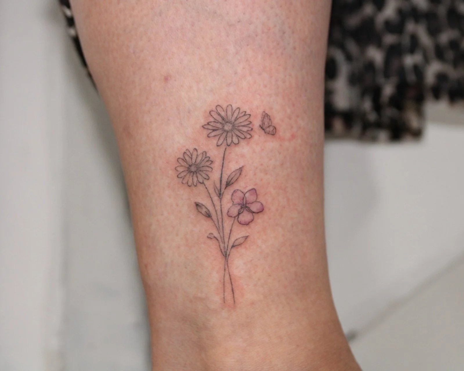 Fine line birth flowers tattoo with butterfly