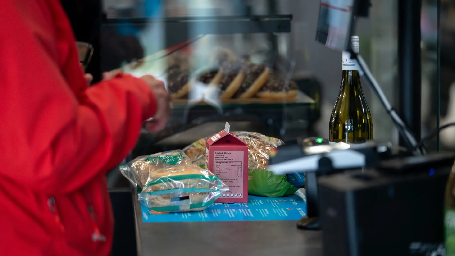 En person er ved at scanne en vare ved selvbetjeningskassen i en af vores butikker.