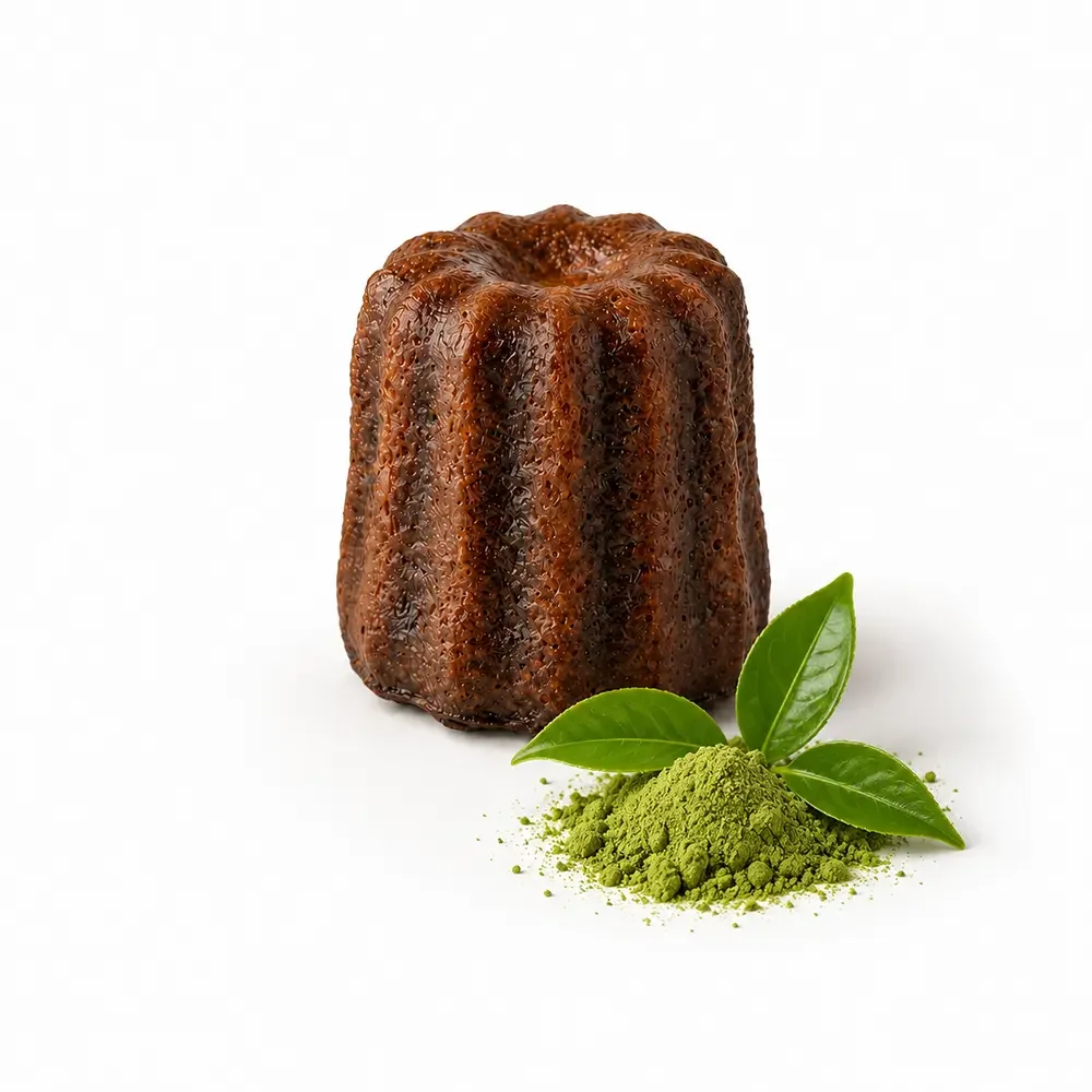 Canelé arrangé au matcha avec feuilles de thé vert et poudre de matcha