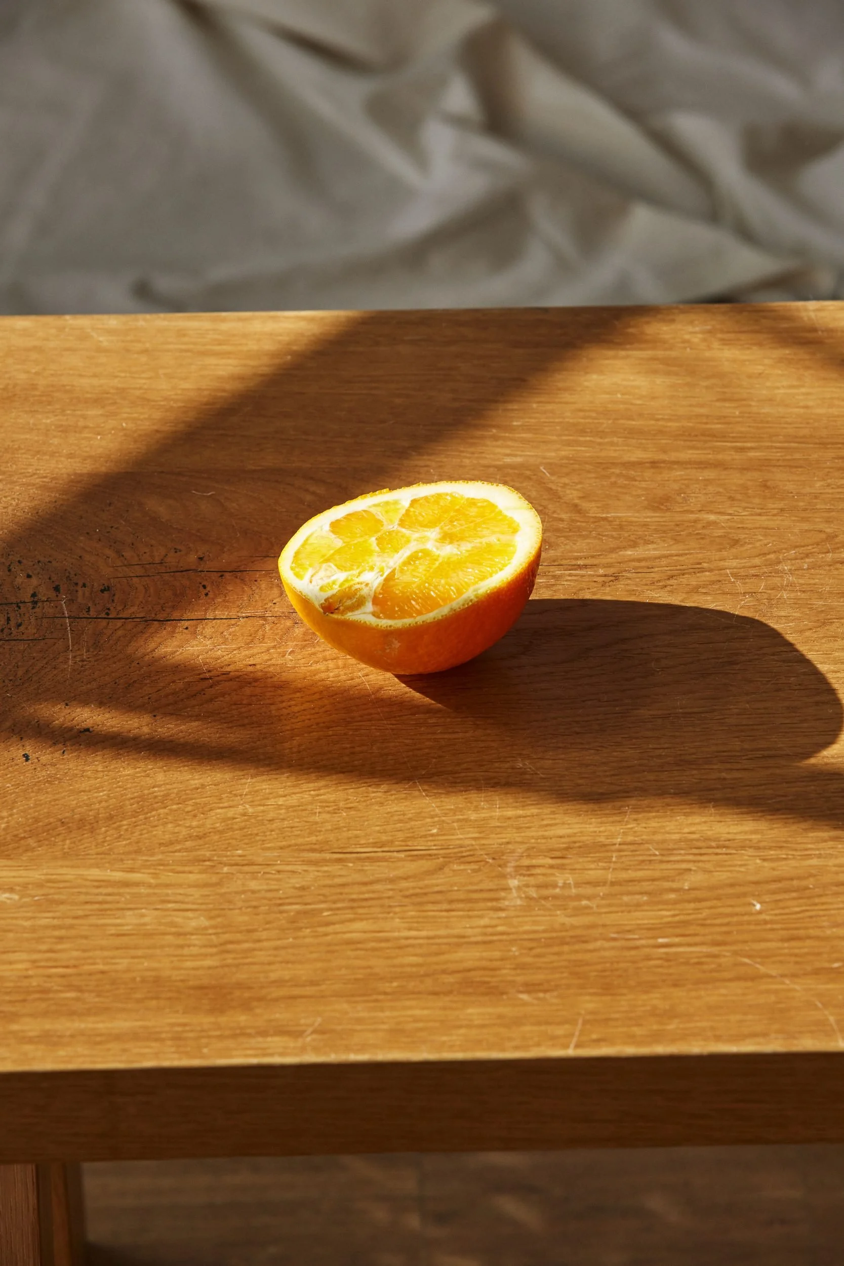Stillleben mit aufgeschnittener Orange auf Holztisch