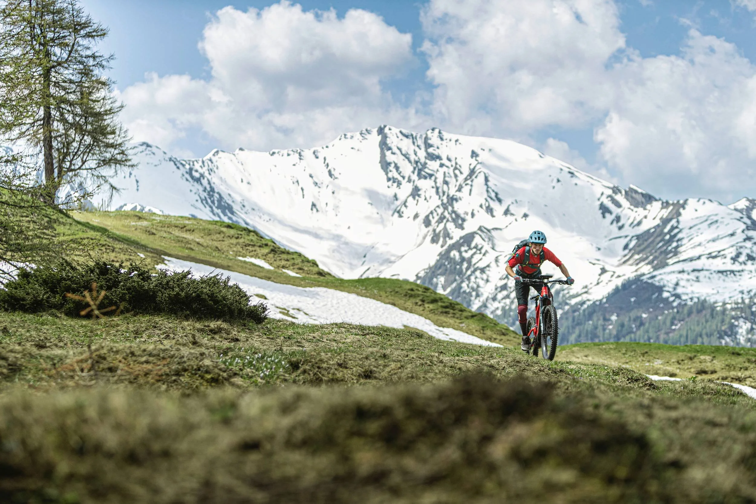 Riese & Müller E-Mountainbike auf Bergkamm vor schneebedeckten Alpengipfeln