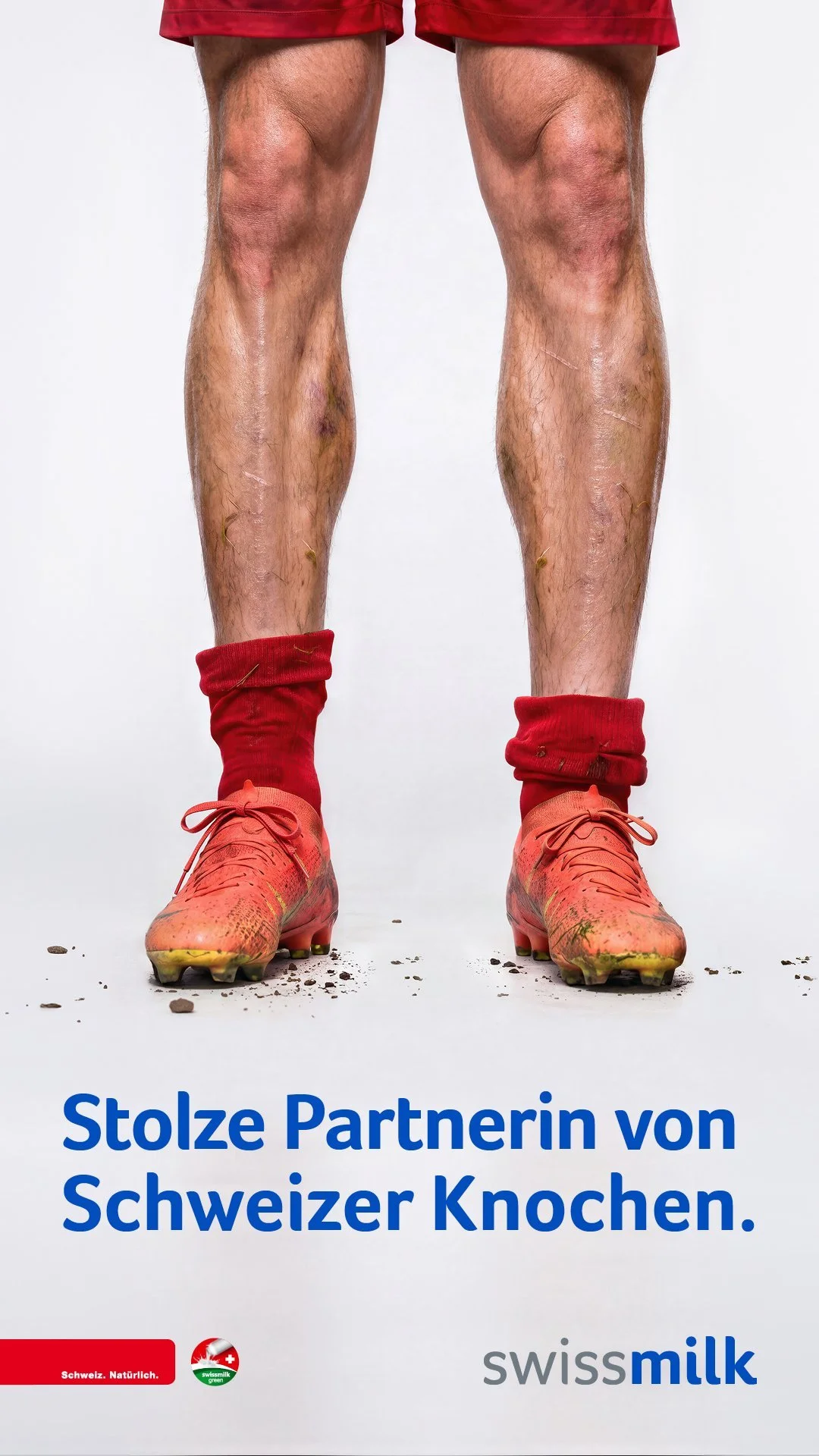 Fußballerbeine in roten Stutzen und Schuhen auf weißem Grund, Swissmilk-Kampagne Schweizer Knochen – Retusche Bildergut.