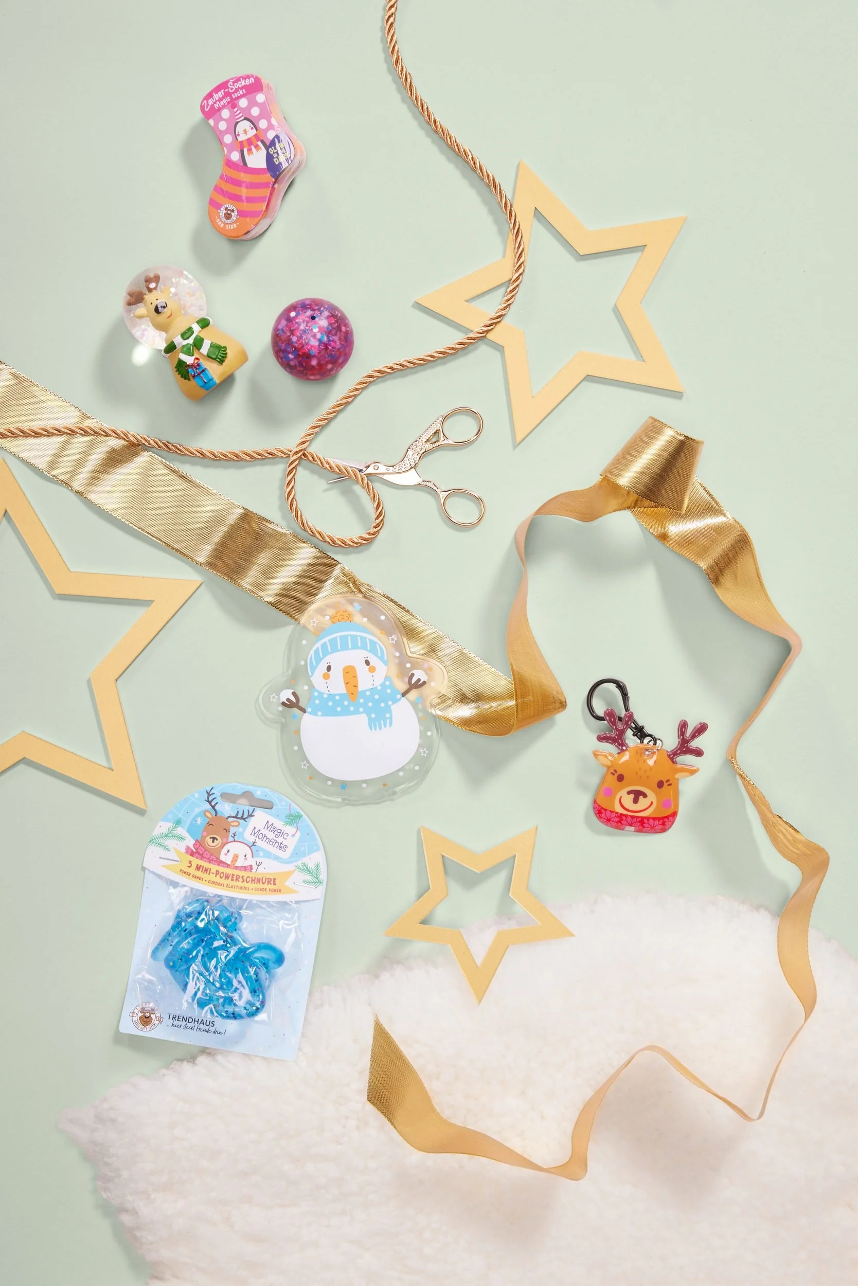 Flatlay mit Geschenkband, Sternen und Weihnachtsanhängern