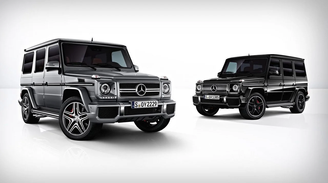 Silberne und schwarze Mercedes G-Klasse AMG nebeneinander im weißen Studio – High-End-Retusche von Bildergut.