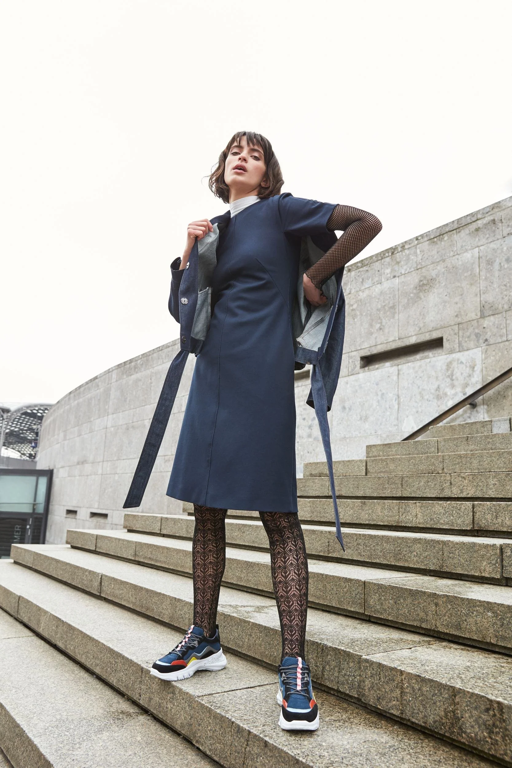 Hellmuth Lookbook 2019: blauer Lagen-Look KASEY auf Treppenstufen, urbane Architektur