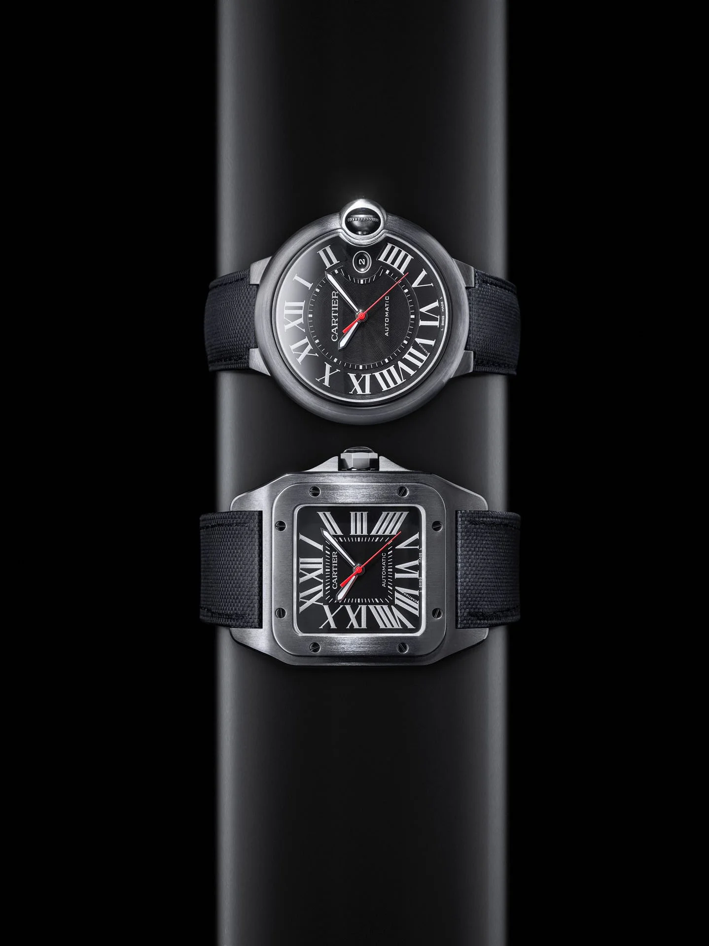 Zwei Cartier-Uhren mit schwarzen Bändern auf schwarzem Zylinder, Ballon Bleu Lookbook – Retusche Bildergut.
