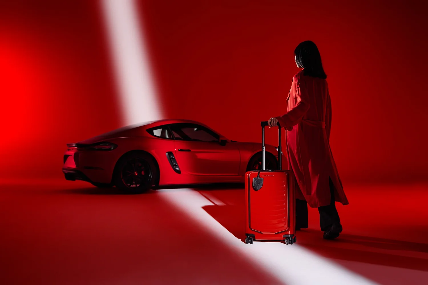 Porsche Design Roadster Hardcase, roter Sportwagen mit rotem Trolley vor rotem Grund