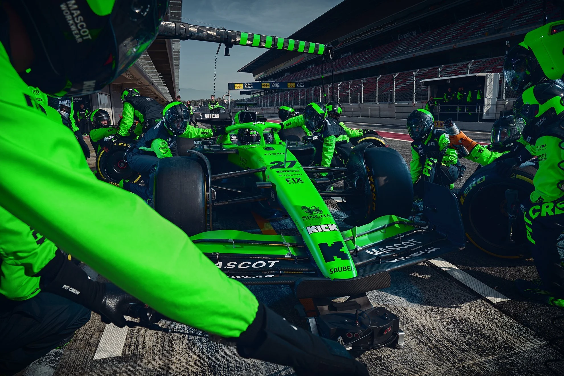 Boxenstopp des Stake F1 Team Kick Sauber mit neongrüner Crew rund um den Rennwagen in Barcelona – Retusche Bildergut.