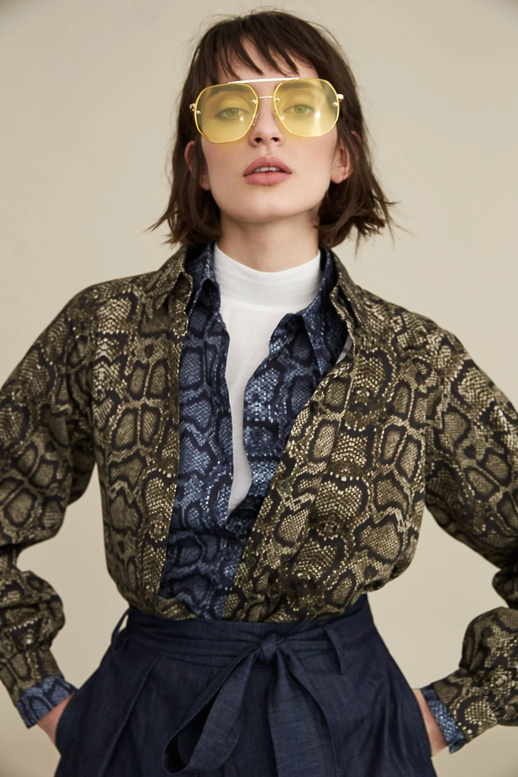 Hellmuth Lookbook 2019: Python-Print-Bluse BETTY über dunkelblauem Rock, gelbe Sonnenbrille