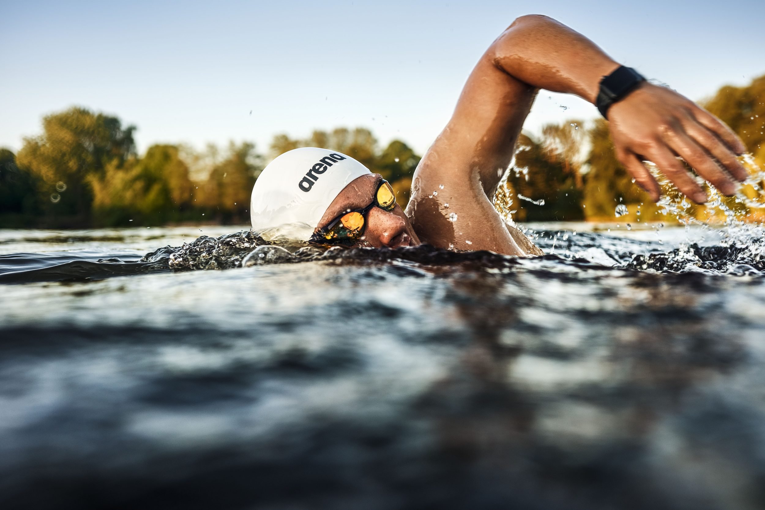 Schwimmer-Editorial von Tim Wendrich: Kraulzug nah, Arm mit Sportuhr über dem Wasser