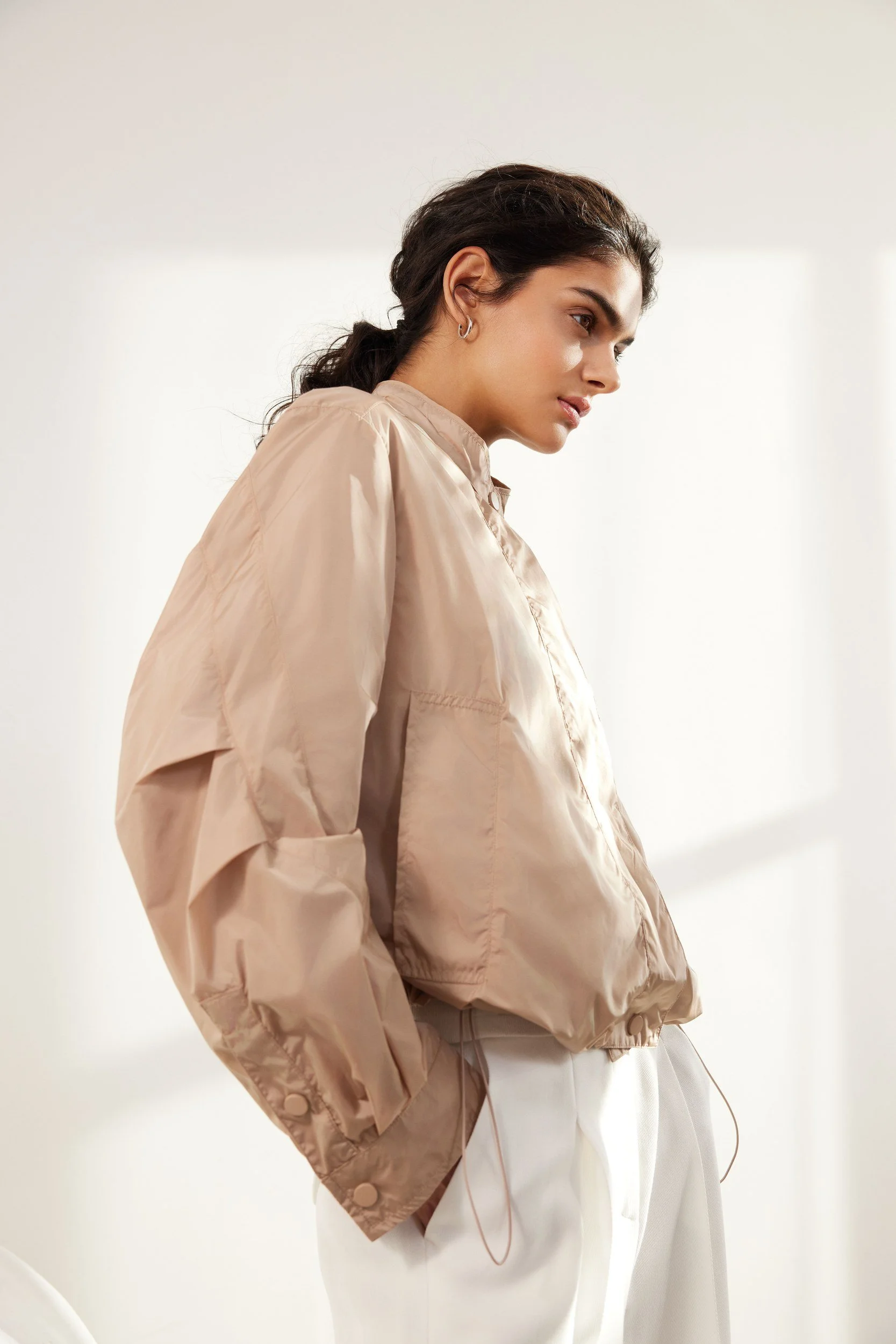 Modehaus Zinser Frühjahr-Sommer 2024: Blouson in Sand im Profil vor Fensterlicht