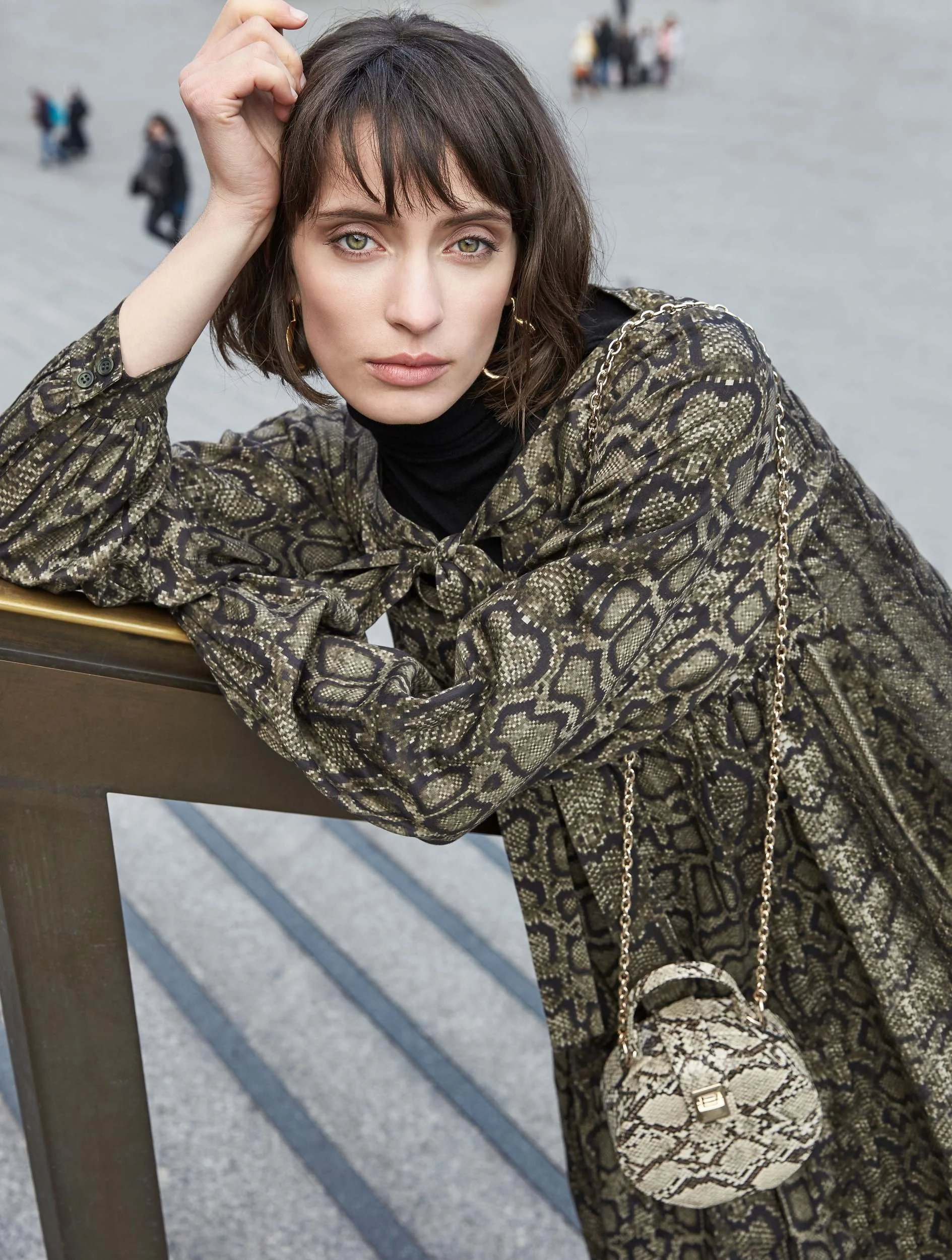Hellmuth Lookbook 2019: Python-Print-Kleid KIWI in Grüntönen, an ein Geländer gelehnt