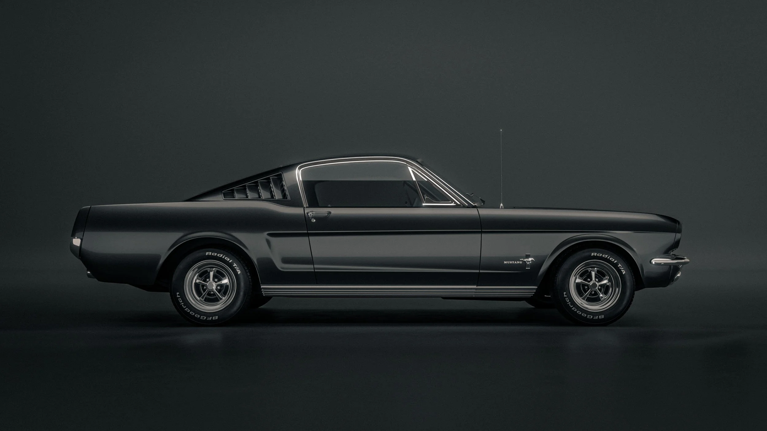 Schwarzer Ford Mustang Fastback Oldtimer in Seitenansicht vor dunklem Studiohintergrund – Retusche Bildergut.